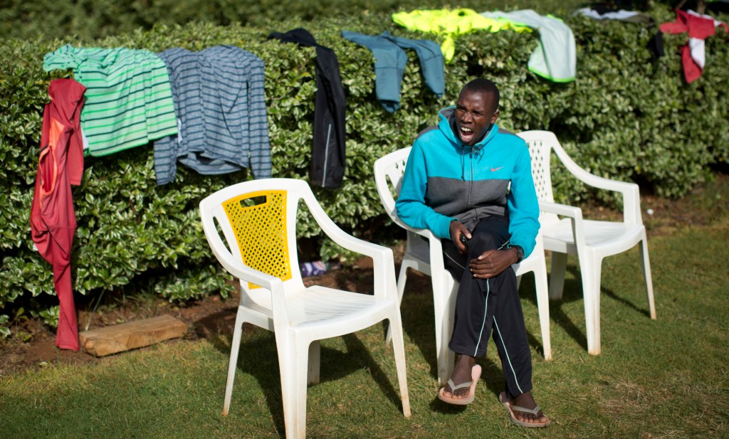 In this Jan. 30, 2016, photo sweat-soaked clothes are draped over bushes to dry in the sun, as runner Nicholas Rotich takes a rest after the morning training run, at the Global Sports camp near the village of Kaptagat in western Kenya. At the high-altitude training camp in Kenya, star athletes turn their back on modernity and bling for a simple life of hard training and communal, egalitarian living. (AP Photo/Ben Curtis)