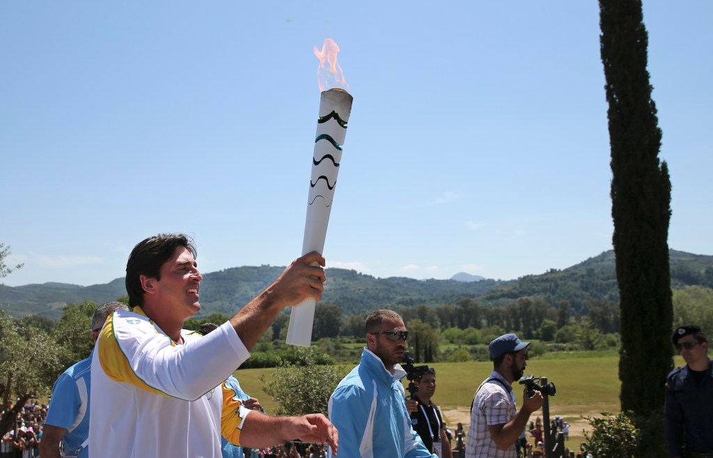 Former Brazilian volleyball player Giovane Gavio runs with a torch with the Olympic flame after the ceremonial lighting of the Olympic flame in Ancient Olympia, Greece, Thursday, April 21, 2016. The flame will be transported by torch relay to the Brazilian city of Rio de Janeiro, which will host the 2016 Olympic Games. (AP Photo/Petros Giannakouris)
