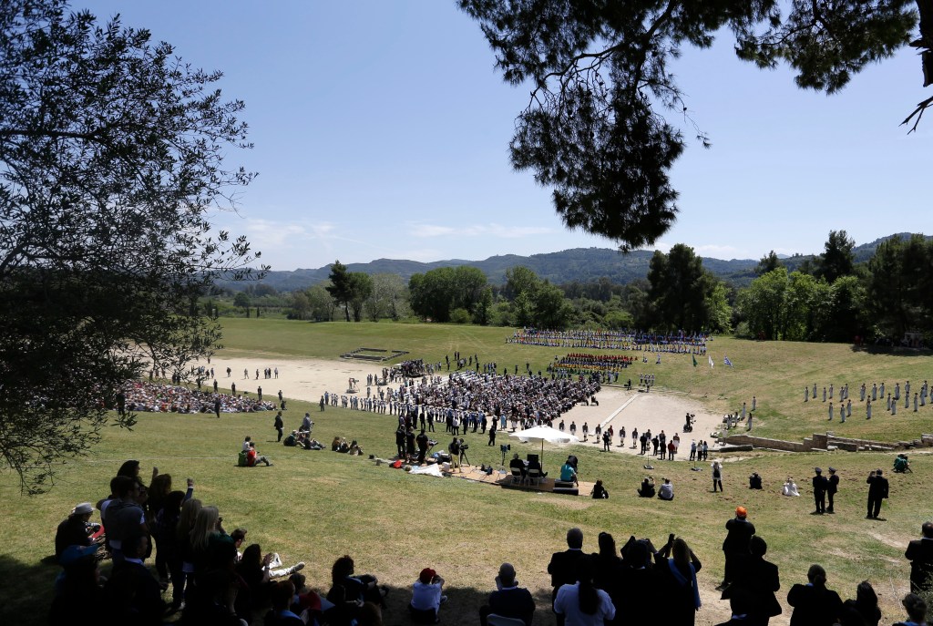 Spectators watch the ceremonial lighting of the Olympic flame in Ancient Olympia, Greece, Thursday, April 21, 2016. The flame will be transported by torch relay to the Brazilian city of Rio de Janeiro, which will host the 2016 Olympic Games. (AP Photo/Thanassis Stavrakis)