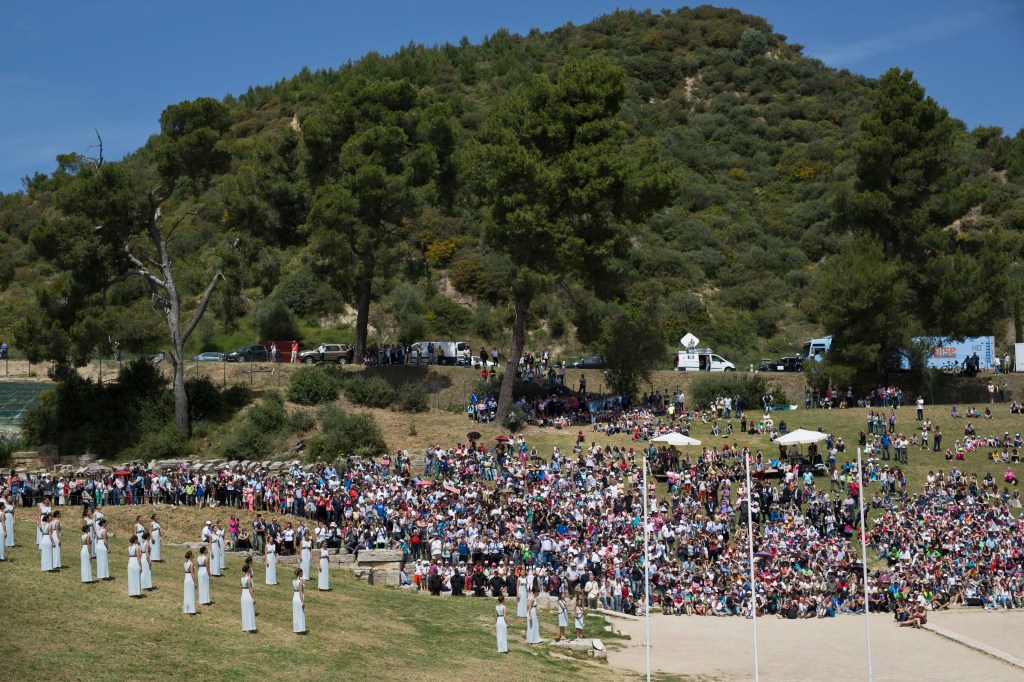 Spectators watch the dress rehearsal for the lighting of the Rio de Janeiro Olympics flame, in Ancient Olympia, southern Greece, on Wednesday, April 20, 2016. The meticulously choreographed ceremony will be repeated Thursday in the ruined birthplace of the ancient Olympics in southern Greece, in the presence of top International Olympic Committee and Rio organizing officials. That will touch off a relay that will conclude with the Rio Games opening ceremony in August. (AP Photo/Petros Giannakouris)