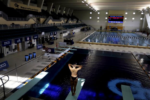 In this Friday, July 22, 2016 photo, a diver stands on a diving board during practice at Georgia Tech's McAuley Aquatic Center, home of the 1996 Summer Olympic Games swimming, diving, and synchronized swimming events in Atlanta. Temporary seating was used during the Olympics, providing a 14,600-seat main pool for swimming, diving and synchronized swimming. There also was a 4,000-seat temporary pool for water polo. After the games, Georgia Tech enclosed the facility and reduced capacity to just under 2,000. This year, it hosted the NCAA swimming championships as well as a pre-Olympic camp for the U.S. swim team before it departed for the Rio Olympics. (AP Photo/David Goldman)