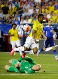 U.S. goalkeeper Brad Guzan, below, stops an attempt on goal by Brazil's Douglas Costa during the first half of an international friendly soccer match Tuesday, Sept. 8, 2015, in Foxborough, Mass. (AP Photo/Stephan Savoia)