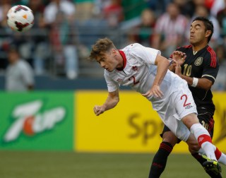 SEATTLE, WA - JULY 11: Nikolas Ledgerwood #2 of Canada heads the ball against Marco Fabian #10 of Mexico at CenturyLink Field on July 11, 2013 in Seattle, Washington. (Photo by Otto Greule Jr/Getty Images)