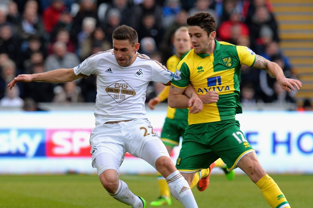 SWANSEA, WALES - MARCH 05: Angel Rangel of Swansea City is tackled by Robbie Brady of Norwich City during the Barclays Premier League match between Swansea City and Norwich City at Liberty Stadium on March 5, 2016 in Swansea, Wales. (Photo by Tony Marshall/Getty Images)
