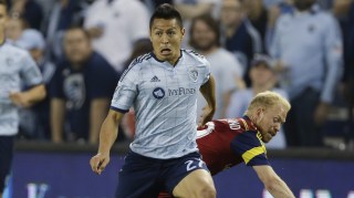 Sporting KC midfielder Roger Espinoza (27) breaks away from Real Salt Lake midfielder Luke Mulholland, back, during the first half of an MLS soccer match in Kansas City, Kan., Saturday, April 11, 2015. (AP Photo/Orlin Wagner)
