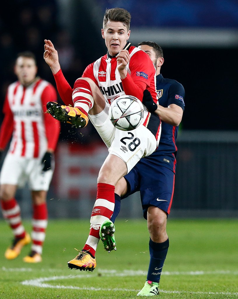 PSVs Marco van Ginkel, front, and Atletico's Tiago Mendez challenge for the ball during the Champions League round of 16 first leg soccer match between PSV Eindhoven and Atletico Madrid at the Philips stadium in Eindhoven, Netherlands, Wednesday, Feb. 24, 2016. (AP Photo/Peter Dejong)
