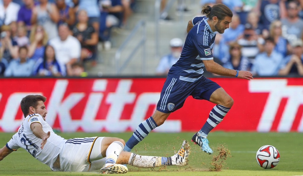 Sporting Kansas City's Graham Zusi, right, avoids a tackle by Los Angeles Galaxy's Tommy Meyer while heading toward the goal during the second half of an MLS soccer game Saturday, July 19, 2014, in Kansas City, Kan. (AP Photo/Topeka Capital-Journal, Chris Neal)