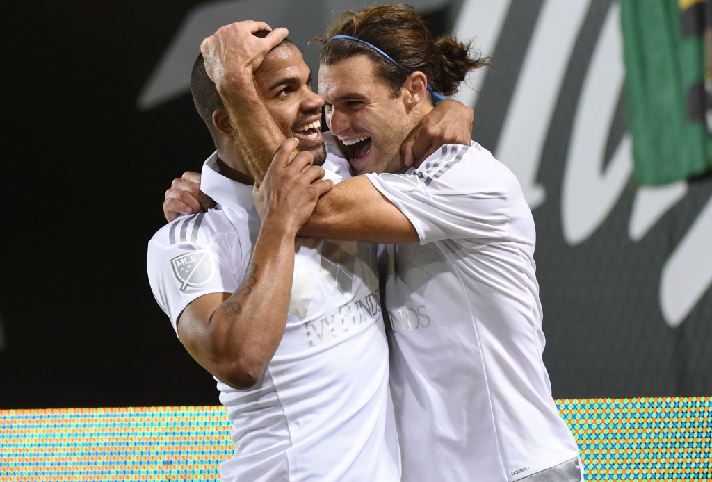 Sporting KC defender Kevin Ellis (4) celebrates with midfielder Graham Zusi (8) after scoring a goal during the second half of a knockout round MLS playoff soccer match against the Portland Timbers in Portland, Ore. on Thursday, Oct. 29, 2015. (AP Photo/Steve Dykes)