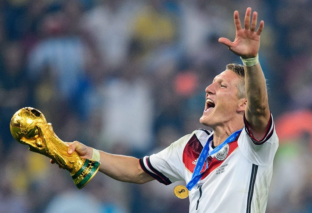 RIO DE JANEIRO, BRAZIL - JULY 13: Bastian Schweinsteiger (L) of Germany and Philipp Lahm (R) of Germany celebrate with the World Cup trophy after defeating Argentina 1-0 in extra time during the 2014 FIFA World Cup Brazil Final match between Germany and Argentina at Maracana on July 13, 2014 in Rio de Janeiro, Brazil. (Photo by Matthias Hangst/Getty Images)