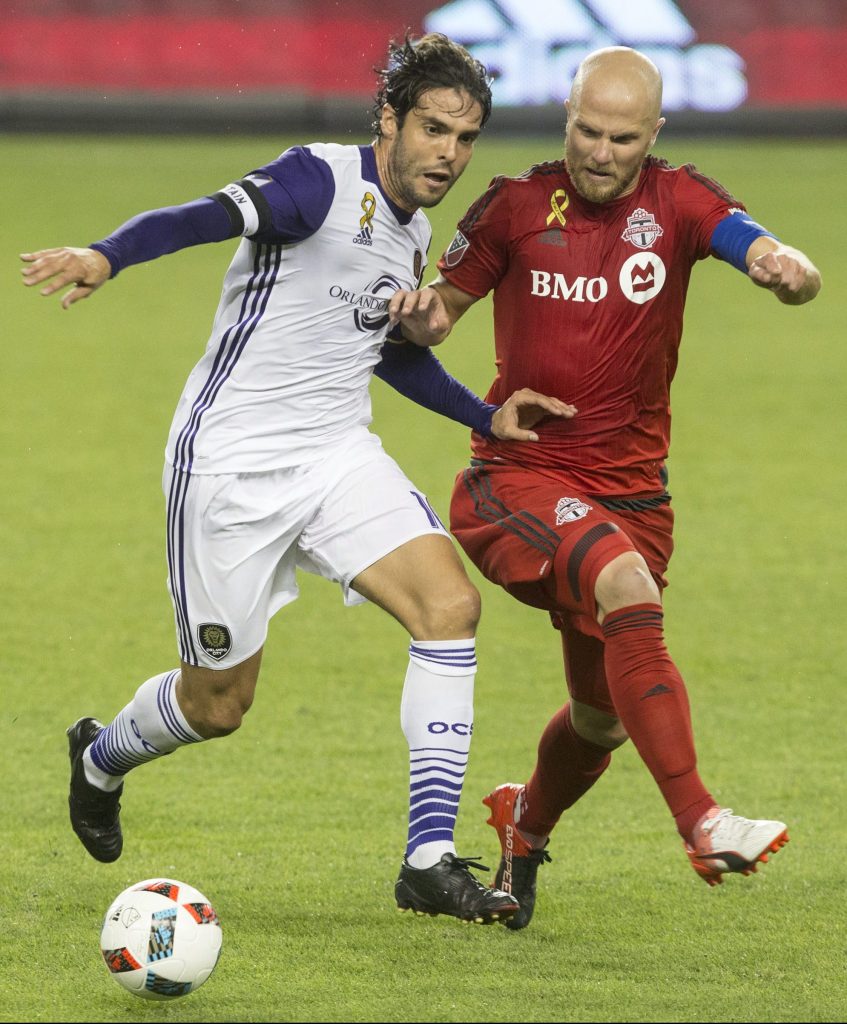 Orlando City's Kaka, center, battles with Toronto FC's Michael Bradley, right, as Amando Cooper looks on during the first half of a soccer game, Wednesday, Sept. 28, 2016 in Toronto. (Chris Young/The Canadian Press via AP)