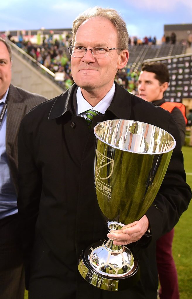 COMMERCE CITY, CO - NOVEMBER 27:  Head Coach Brian Schmetzer of the Seattle Sounders smiles as he holds the MLS Western Conference trophy alongside General Manager Garth Lagerwey after a 1-0 win over the Colorado Rapids at Dick's Sporting Goods Park on November 27, 2016 in Commerce City, Colorado.  (Photo by Harry How/Getty Images)