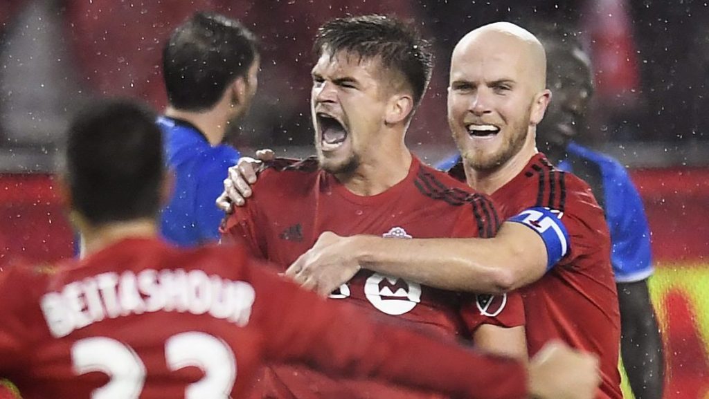 Toronto FC defender Nick Hagglund, center, celebrates his goal against the Montreal Impact with teammates Michael Bradley, right, and Steven Beitashour (33) during the second half of the second leg of MLS Eastern Conference championship series, in Toronto on Wednesday, Nov. 30, 2016. (Frank Gunn/The Canadian Press via AP)