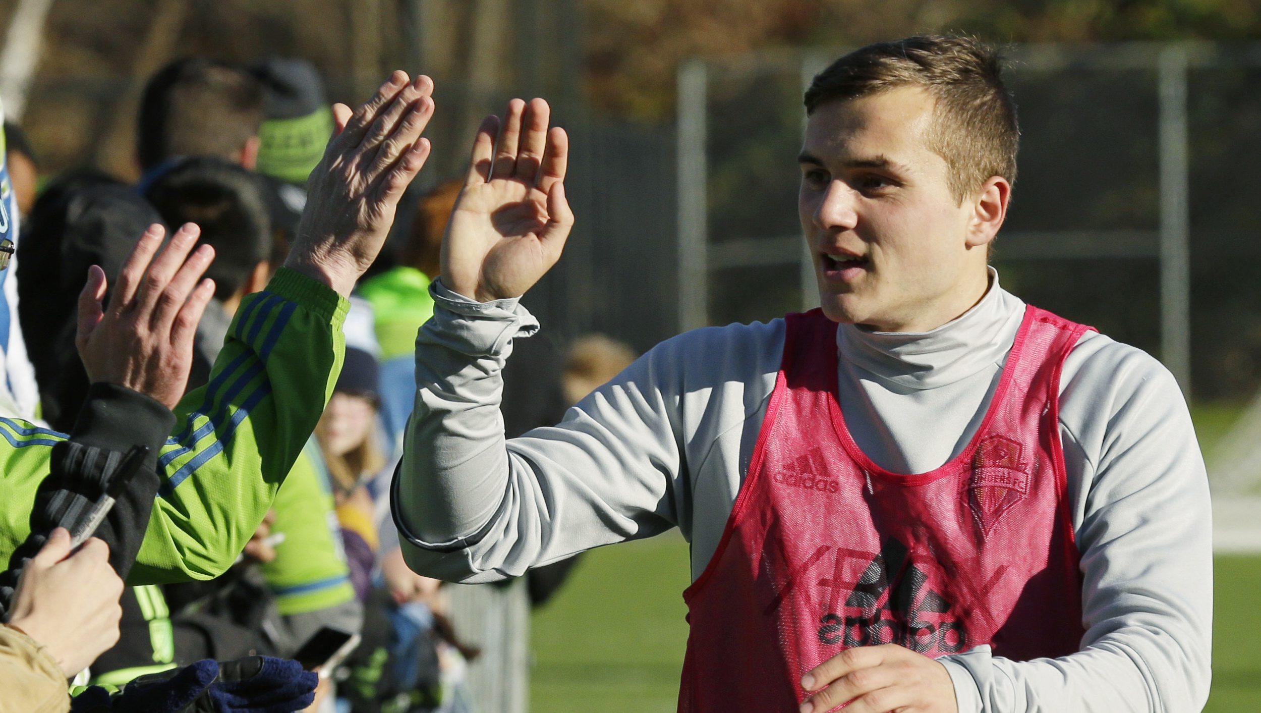 Seattle Sounders forward Jordan Morris greets fans who gathered to send off the team after MLS soccer training, Wednesday, Dec. 7, 2016, in Tukwila, Wash. The Sounders were scheduled to travel to Toronto later Wednesday to prepare to face Toronto FC in the MLS Cup Saturday, Dec. 10, 2016. (AP Photo/Ted S. Warren)