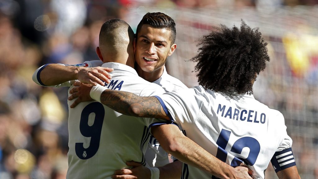 Real Madrid's Cristiano Ronaldo, centre, celebrates a goal with teammates Marcelo, right, and Karim Benzema during the Spanish La Liga soccer match between Real Madrid and Granada at the Santiago Bernabeu stadium in Madrid, Saturday, Jan. 7, 2017. Benzema and Ronaldo scored one goal each in Real Madrid's 5-0 victory. (AP Photo/Francisco Seco)