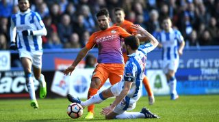 HUDDERSFIELD, ENGLAND - FEBRUARY 18: Sergio Aguero of Manchester City (C) and Mark Hudson of Huddersfield Town (R) both stretch to reach the balll during The Emirates FA Cup Fifth Round match between Huddersfield Town and Manchester City at John Smith's Stadium on February 18, 2017 in Huddersfield, England. (Photo by Gareth Copley/Getty Images)