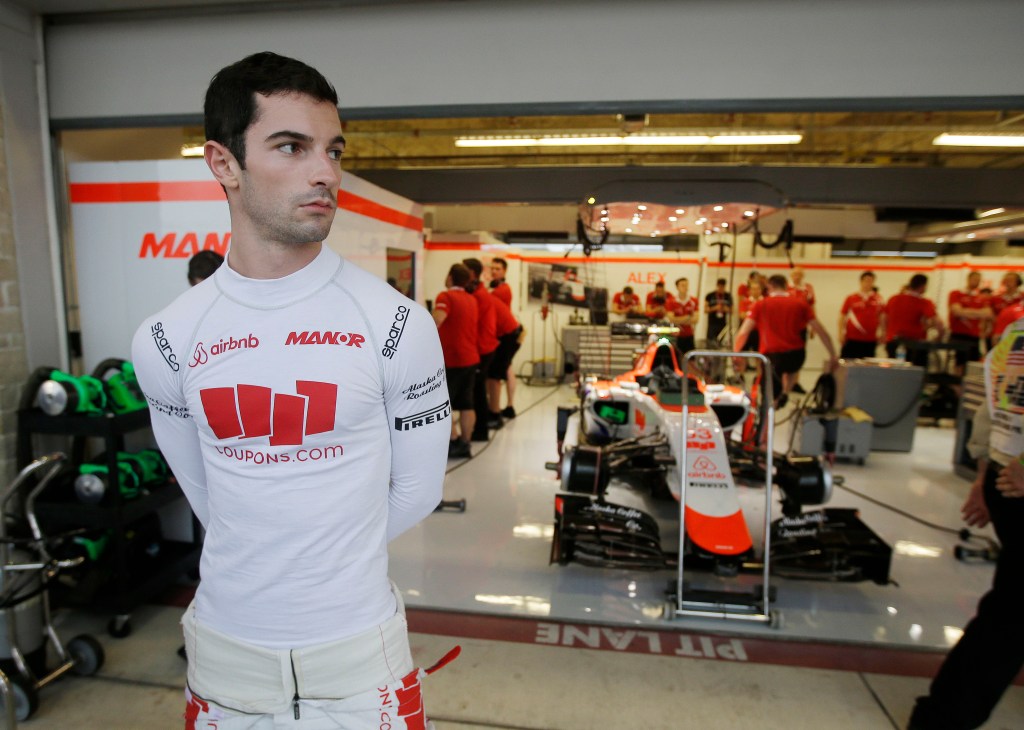 Manor driver Alexander Rossi stands outside of his garage during a delay in the second practice session for the Formula One U.S. Grand Prix auto race at the Circuit of the Americas, Friday, Oct. 23, 2015, in Austin, Texas. (AP Photo/Darron Cummings)
