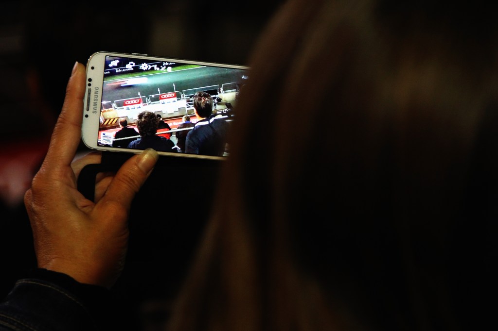 LE MANS, FRANCE - JUNE 15: Fan takes a picture on her camera phone during practice for the Le Mans 24 Hour race at the Circuit de la Sarthe on June 15, 2016 in Le Mans, France. (Photo by Ker Robertson/Getty Images)