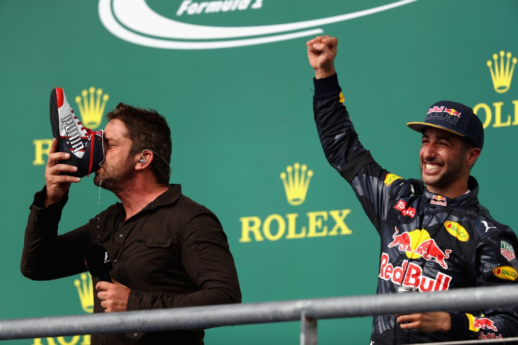 AUSTIN, TX - OCTOBER 23: Actor Gerard Butler does a shoey on the podium with Daniel Ricciardo of Australia and Red Bull Racing after Daniel finished third in the race during the United States Formula One Grand Prix at Circuit of The Americas on October 23, 2016 in Austin, United States. (Photo by Clive Mason/Getty Images)