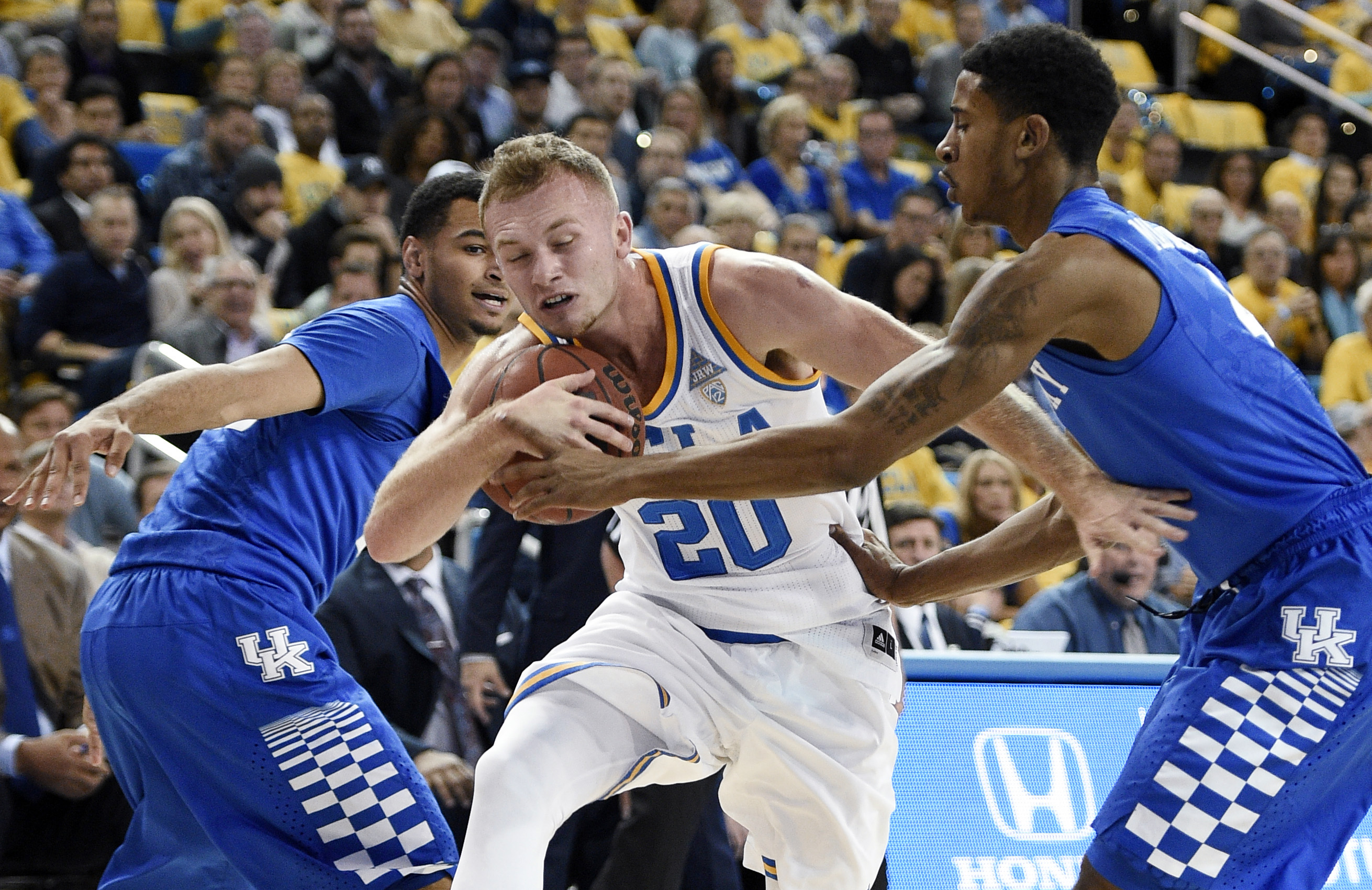 UCLA guard Bryce Alford, center, attempts to move the ball past Kentucky guard Charles Matthews, right, as Jamal Murray, left, helps defend during the first half of an NCAA college basketball game in Los Angeles, Thursday, Dec. 3, 2015. (AP Photo/Kelvin Kuo)