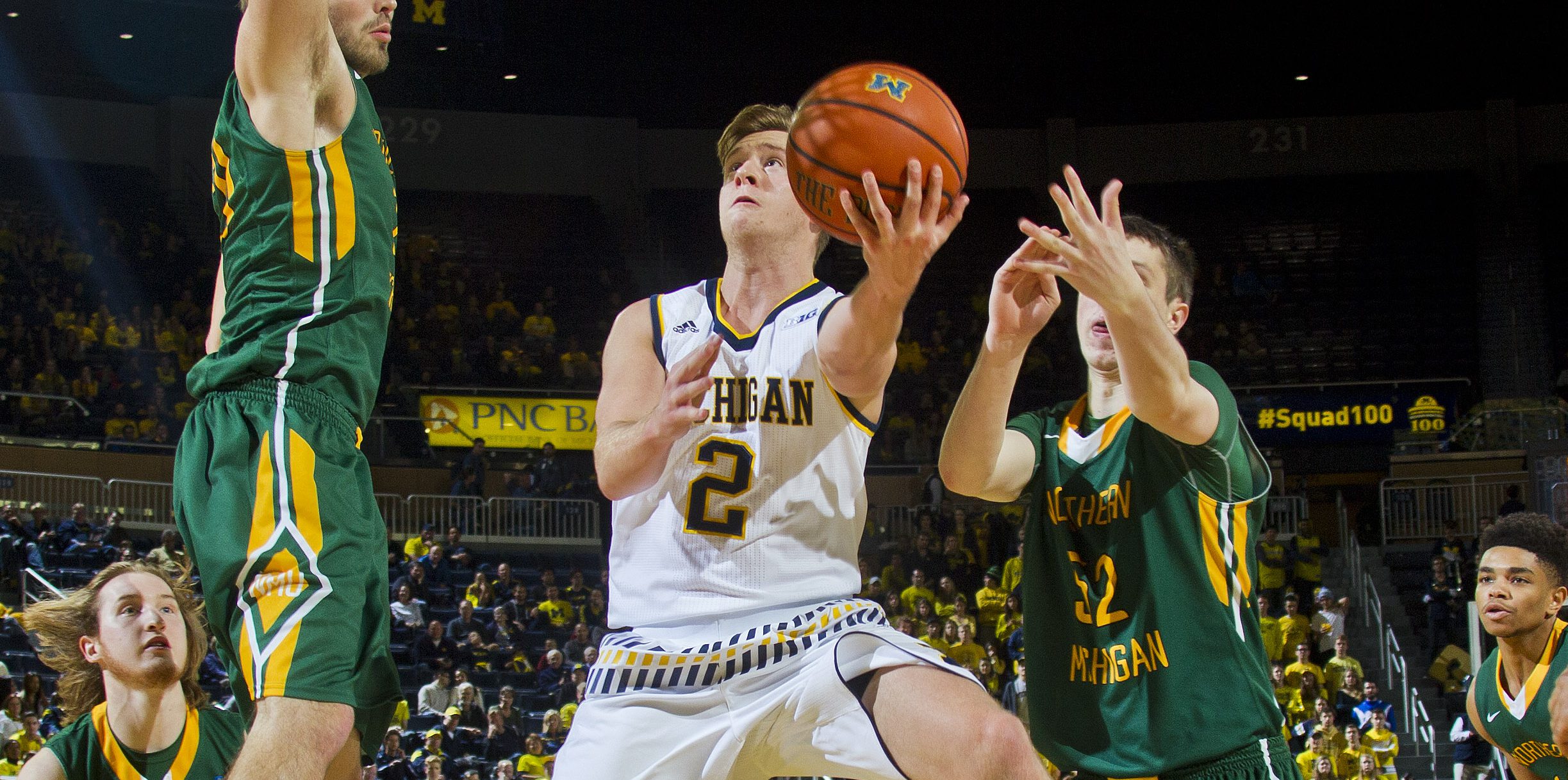 Michigan guard Spike Albrecht (2) makes a layup between Northern Michigan forward Brett Branstrom, top left, and center Vejas Grazulis (52) in the second half of an NCAA college basketball game at Crisler Center in Ann Arbor, Mich., Friday, Nov. 13, 2015. Michigan won 70-44. (AP Photo/Tony Ding)