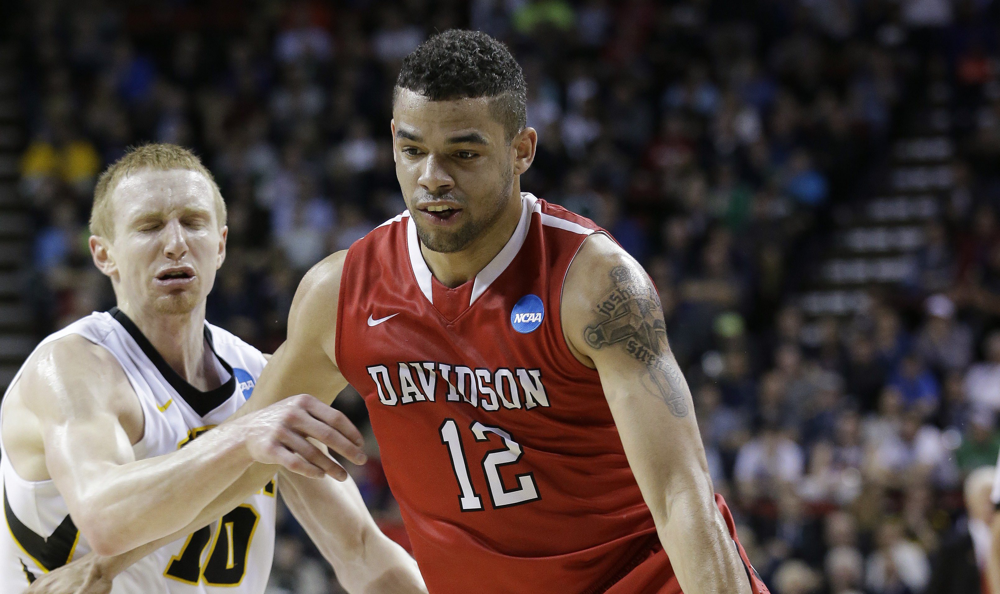 Davidson's Jack Gibbs (12) tries to drive past Iowa's Mike Gesell during the first half of an NCAA tournament college basketball game in the Round of 64 in Seattle, Friday, March 20, 2015. (AP Photo/Elaine Thompson)