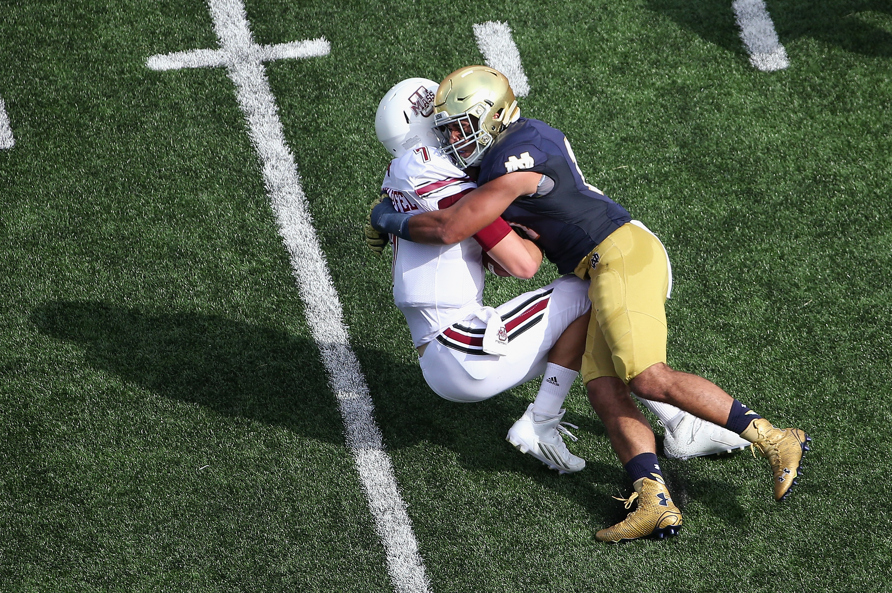 SOUTH BEND, IN - SEPTEMBER 26: Blake Frohnapfel #7 of the Massachusetts Minutemen is sacked by James Onwualu #17 of the Notre Dame Fighting Irish at Notre Dame Stadium on September 26, 2015 in South Bend, Indiana. (Photo by Jonathan Daniel/Getty Images)