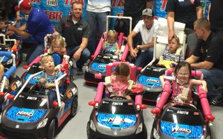Many of the kids who received a specially fitted car to help with their mobility issues at a Go Baby Go event Wednesday at Tommy Baldwin Racing. (Photo by Dustin Long)