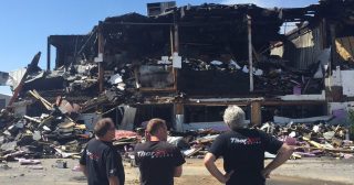 Members of ThorSport Racing survey the damage from a pre-dawn fire at the race shop Monday. (Photo by Jilly Burns/Sandusky Register)