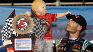 ROSSBURG, OH - JULY 20: Kyle Larson, driver of the #24 DC Solar Chevrolet, and his son Owen Larson hold the NASCAR Camping World Series 4th Annual Aspen Dental Eldora Dirt Derby 150 trophy after winning at Eldora Speedway on July 20, 2016 in Rossburg, Ohio. (Photo by Brian Lawdermilk/Getty Images)