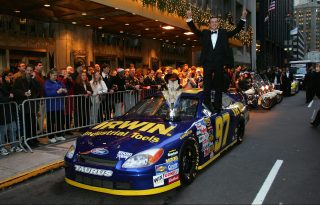 NEW YORK - DECEMBER 03: 2004 NASCAR NEXTEL Cup Series Champion Kurt Busch stands on top of his car while posing with the NASCAR NEXTEL Cup trophy prior the 2004 NASCAR Nextel Cup Awards outside of the Waldorf Astoria on December 3, 2004 in New York City. (Photo by Chris Trotman/Getty Images for NASCAR)