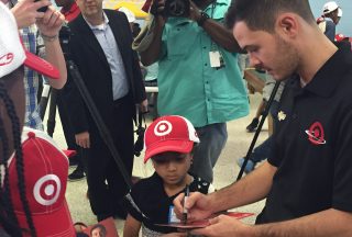 Kyle Larson signs an autograph for a child at the Salvation Army Boys and Girls Club on Wednesday. Larson and Target presented the Charlotte, North Carolina, club with toys. (Photo: Dustin Long)